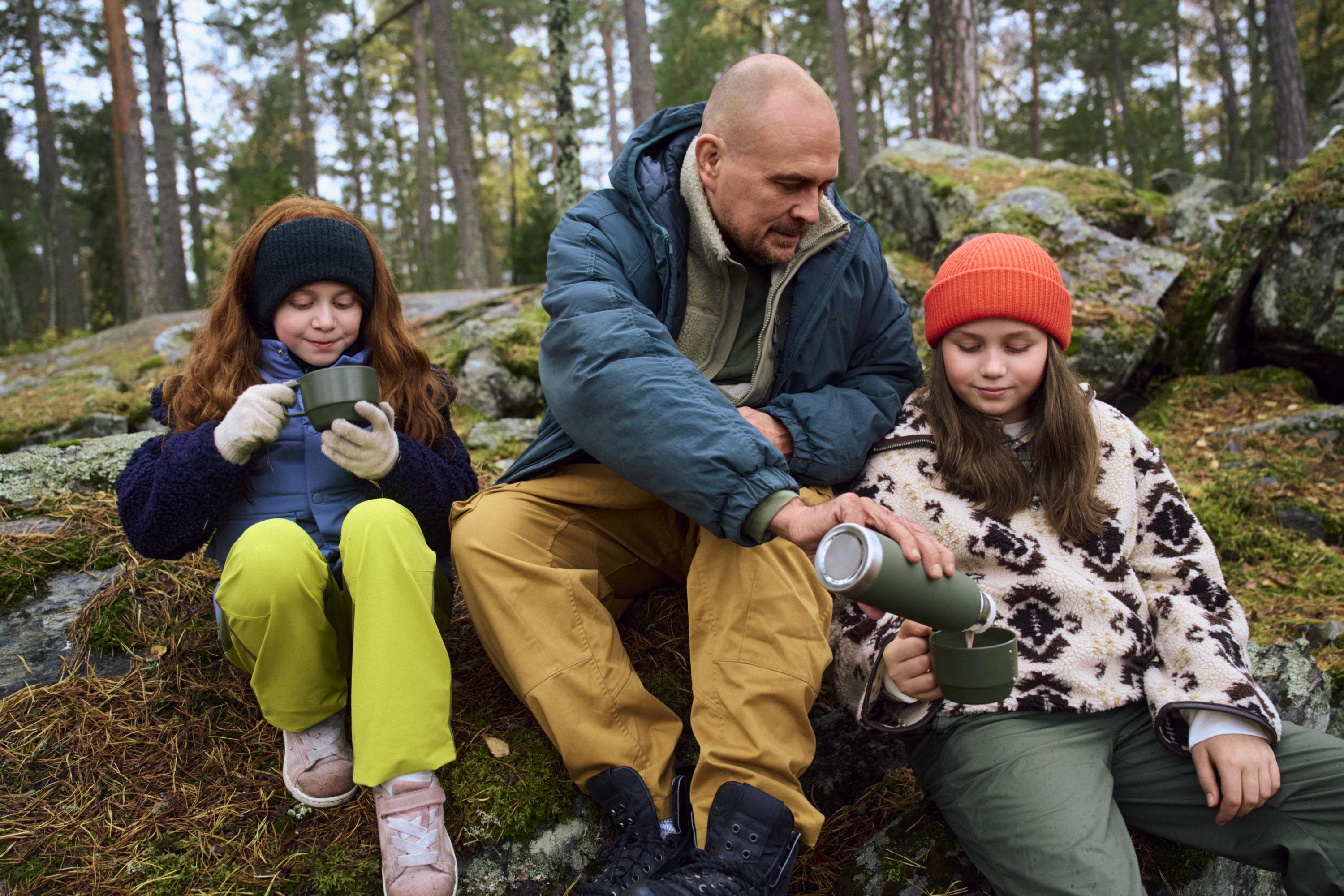 En familj har picknick i skogen.