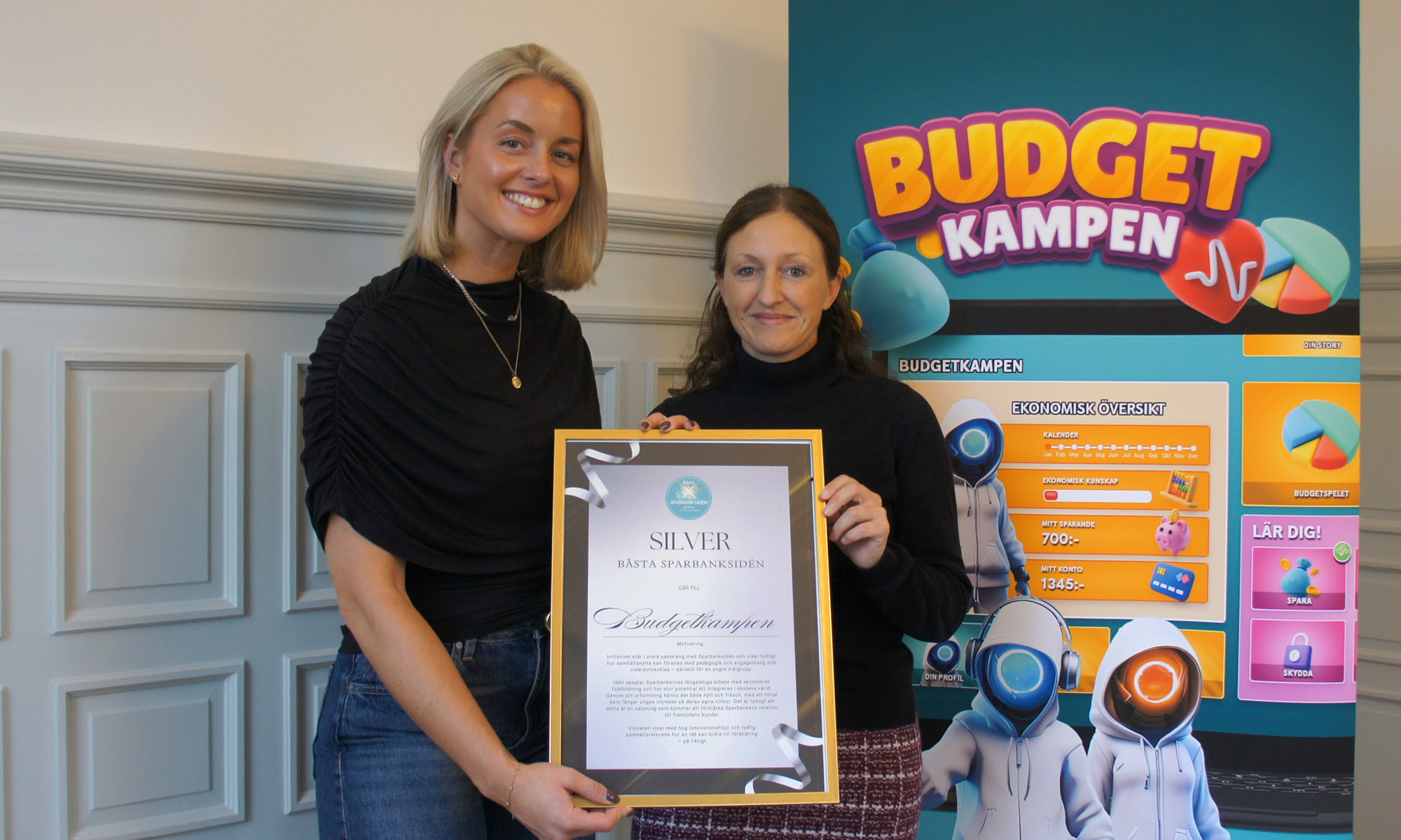 Ingrid Aronsson och Hanna Sahlström håller upp diplom för silverplatsen i "Bästa Sparbanksidén" 2025