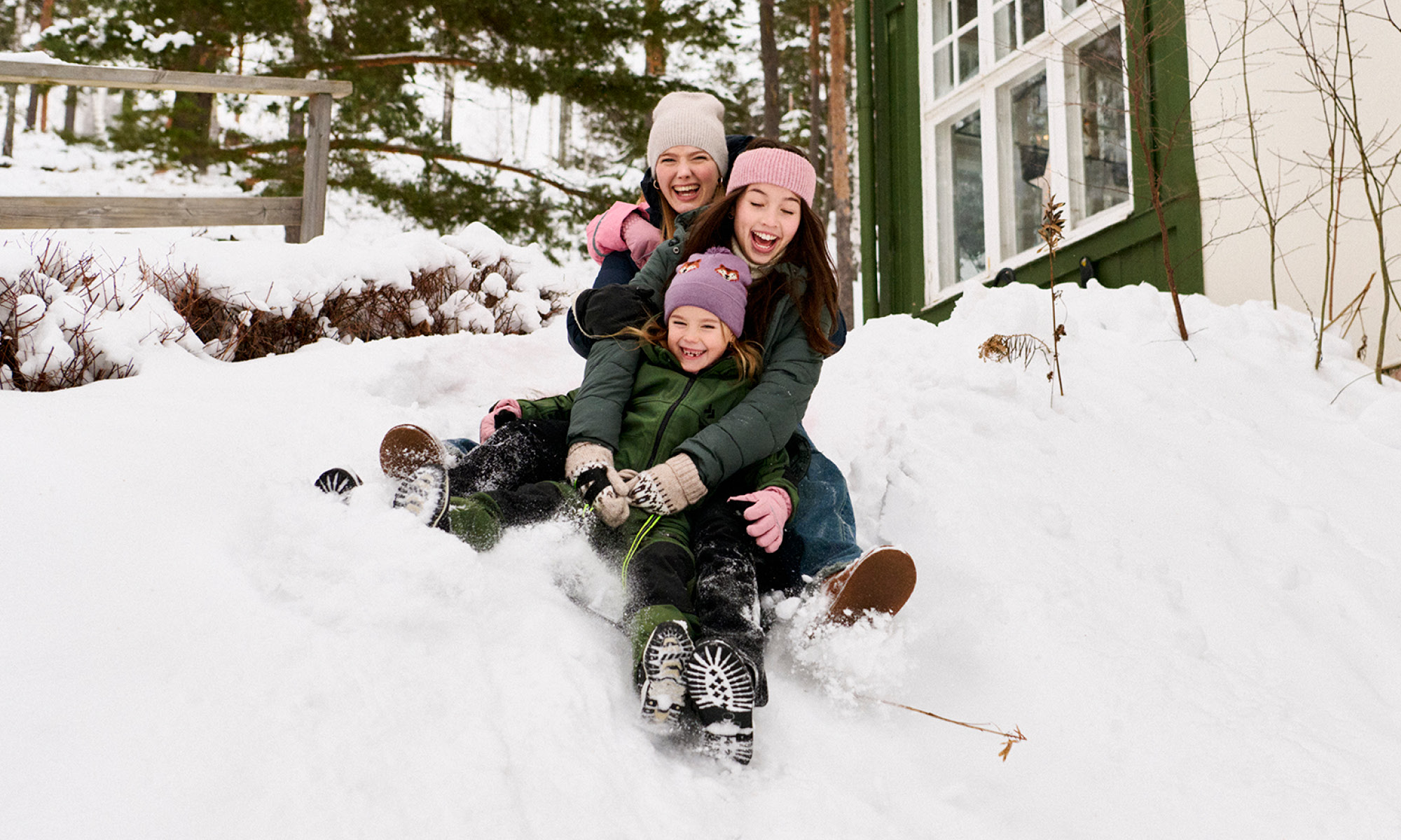Barn åker pulka utanför hus